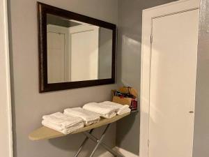 a bathroom with a shelf with towels and a mirror at Cozy 1 BR, walk to subway, Free WiFi & Parking in Belleville +29 photos