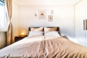 KüssabergにあるHoliday Apartment NAMASTAYの白いシーツと窓のあるベッドのある寝室