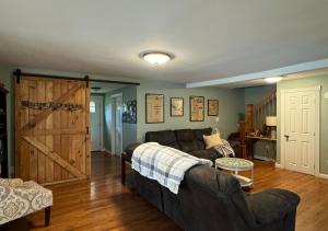 a living room with a couch and a barn door at Northern Maine Getaway in Fort Fairfield