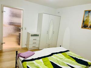 a bedroom with a bed and a dresser in it at Ferienwohnung Sommerblüte in Schweich +4 photos