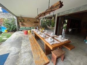 a long wooden table with benches at Casa dos Sonhos em São Miguel dos Milagres in São Miguel dos Milagres +49 photos