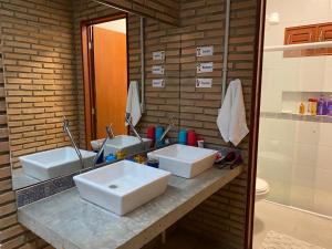 a bathroom with two sinks and a mirror at Casa dos Sonhos em São Miguel dos Milagres in São Miguel dos Milagres
