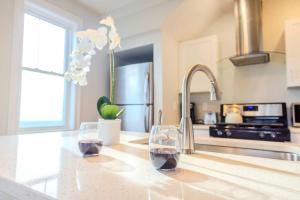 two wine glasses sitting on a counter in a kitchen at Jennifer's Amazing City View Private Apartment in Providence