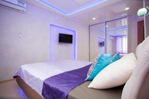 チェリャビンスクにあるInnHome Apartments Tsvillinga 34のベッドルーム(青い枕のベッド1台、テレビ付)