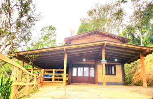 Casa pequeña con puerta de madera y porche en Casa dos Alpes com Jacuzzi hidro e Lareira, en Santo Amaro da Imperatriz