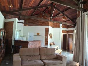 a living room with a couch and a kitchen at Caminho da Toca in Passa Quatro