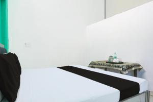 a white bed with a side table in a room at Hotel O SAMRAT HOTEL in Alīgarh +21 photos