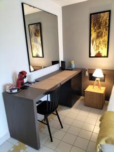 a room with a desk with a mirror and a bed at Studio AMÉ - Manganao in Saint-François