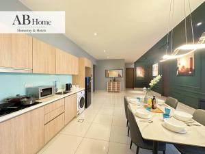 a kitchen with a long table and chairs in a room at ABHOME "ART MUSEUM SUITE" #GreenHaven #360"City & Sea View #Masai #JB in Johor Bahru