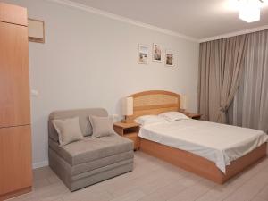 a bedroom with a bed and a chair at Studio Sea Breeze Veranda in Santa Marina in Sozopol +61 photos