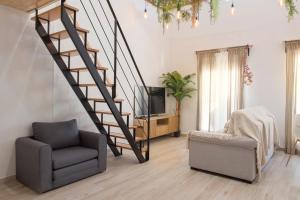 a living room with a staircase and a chair and a television at Agua Viva Deluxe in Málaga