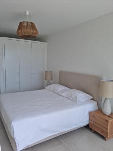 una camera da letto con un letto bianco e due lampade di Maktub @ Oásis Mar a Portimão
