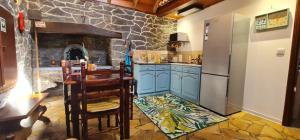 a kitchen with a refrigerator and a stone wall at Casa Monte de Paz in Calheta