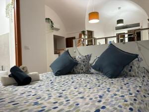 a bedroom with a large bed with blue pillows at Casa Rosetta al Centro in Regalbuto