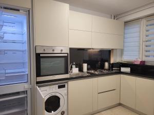 a kitchen with a washing machine and a microwave at 2Na-Apart in Cluj-Napoca