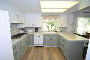 a kitchen with white cabinets and white appliances at Brummett Lodge in Bass Lake