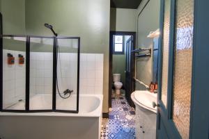 a bathroom with a tub and a toilet and a sink at Appartement ATHOS - Hyper Centre - Familiale in Orléans +31 photos