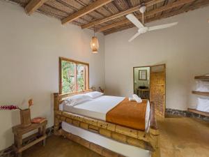 un dormitorio con una cama y un espejo en Tayrona Cachaco River Ecohostal, en El Zaino