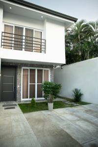 a white house with a black door and a porch at Townhouse - Centrico - Modern - 3 hab - Patio in San Pedro Sula