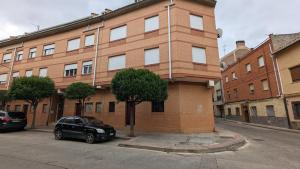 a black car parked in front of a brick building at Loft de ensueño con piscina en La Rioja in Villamediana de Iregua