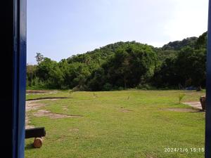 a field of grass with a hill in the background at Chácara Acolhedora! in Majé