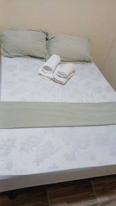 a bed with two towels on top of it at Chácara Acolhedora! in Majé