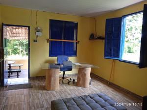 a room with a desk and blue windows at Chácara Acolhedora! in Majé