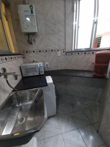 a bathroom with a sink and a washing machine at Apê com 2 quartos super bem localizado em copa in Rio de Janeiro