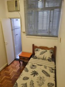 a small bedroom with a bed and a window at Apê com 2 quartos super bem localizado em copa in Rio de Janeiro