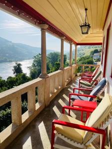 een rij stoelen op een balkon met uitzicht op het water bij Historic Douro Valley Quinta in Lamego