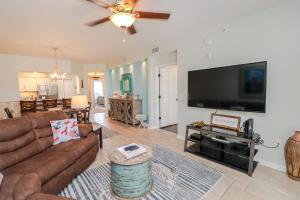 een woonkamer met een bank en een flatscreen-tv bij Seaside at Anastasia B105 in St. Augustine