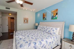 een slaapkamer met een bed en een blauwe muur bij Seaside at Anastasia B105 in St. Augustine +31 foto's