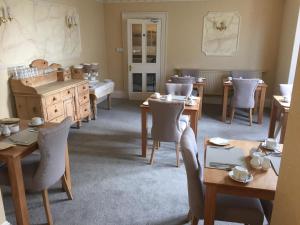 a dining room with wooden tables and chairs at Lynton House in Llandudno