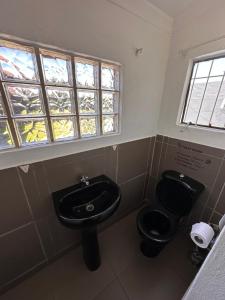 La salle de bains est pourvue de toilettes noires et d'un lavabo. dans l'établissement De Hill Leisure Guest House, à Johannesbourg 14 autres photos