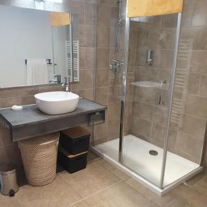 a bathroom with a sink and a glass shower at Appartement Porto - Ota in Porto Ota