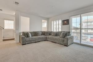 a living room with a couch in a room with windows at 10 Mi to The Strip Spacious Extended Vegas Stay! in Las Vegas