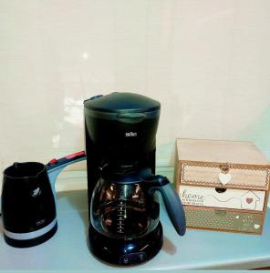 a black coffee maker sitting on a table next to a box at Angie's House Volos in Volos