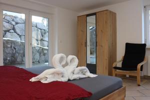 a bedroom with swans made out of towels on a bed at Ferienwohnung Schwarzwaldtraum mit Balkon - Mein Schwarzwaldhäusle in Todtmoos +27 photos