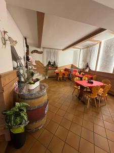 a restaurant with tables and chairs and a room with tables at Hotel Belfort in Spormaggiore