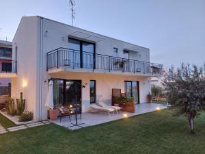 a white house with a balcony and a yard at Nacàri Home in Giardini Naxos