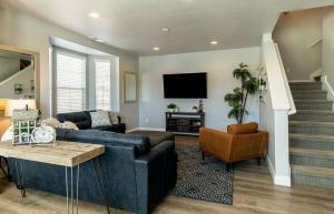 a living room with a blue couch and a tv at Beautiful Sun Villa at The Casitas Sienna Hills in Washington