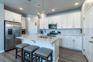 a kitchen with white cabinets and a large island with bar stools at Beautiful Sun Villa at The Casitas Sienna Hills in Washington