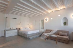 a white bedroom with a bed and a couch at Beyond Blue Suite in Mýkonos City +12 photos