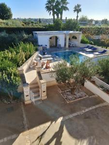una casa con piscina e due persone sedute in aviatore di Villa Coco Monopoli a Monopoli