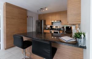 a kitchen with a black counter and wooden cabinets at Détente Orford 111 condo/chalet in Orford