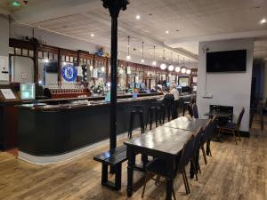 a bar with tables and chairs in a restaurant at Queen Elizabeth Hostel in London