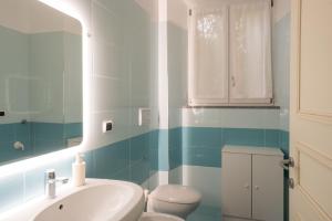 a bathroom with a sink and a toilet and a mirror at Appartamento Moderno - Rho Fiera Milano in Rho