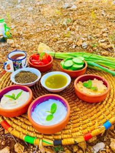 einen Tisch mit Würfeln aus Dip und Gemüse darauf in der Unterkunft Nassen House in Udhruḩ