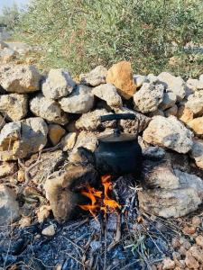 Ein Topf über einem Feuer in einem Haufen Steine in der Unterkunft Nassen House in Udhruḩ + 19 Fotos