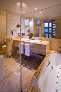 a large bathroom with two sinks and a tub at Hotel Meliá Bilbao in Bilbao